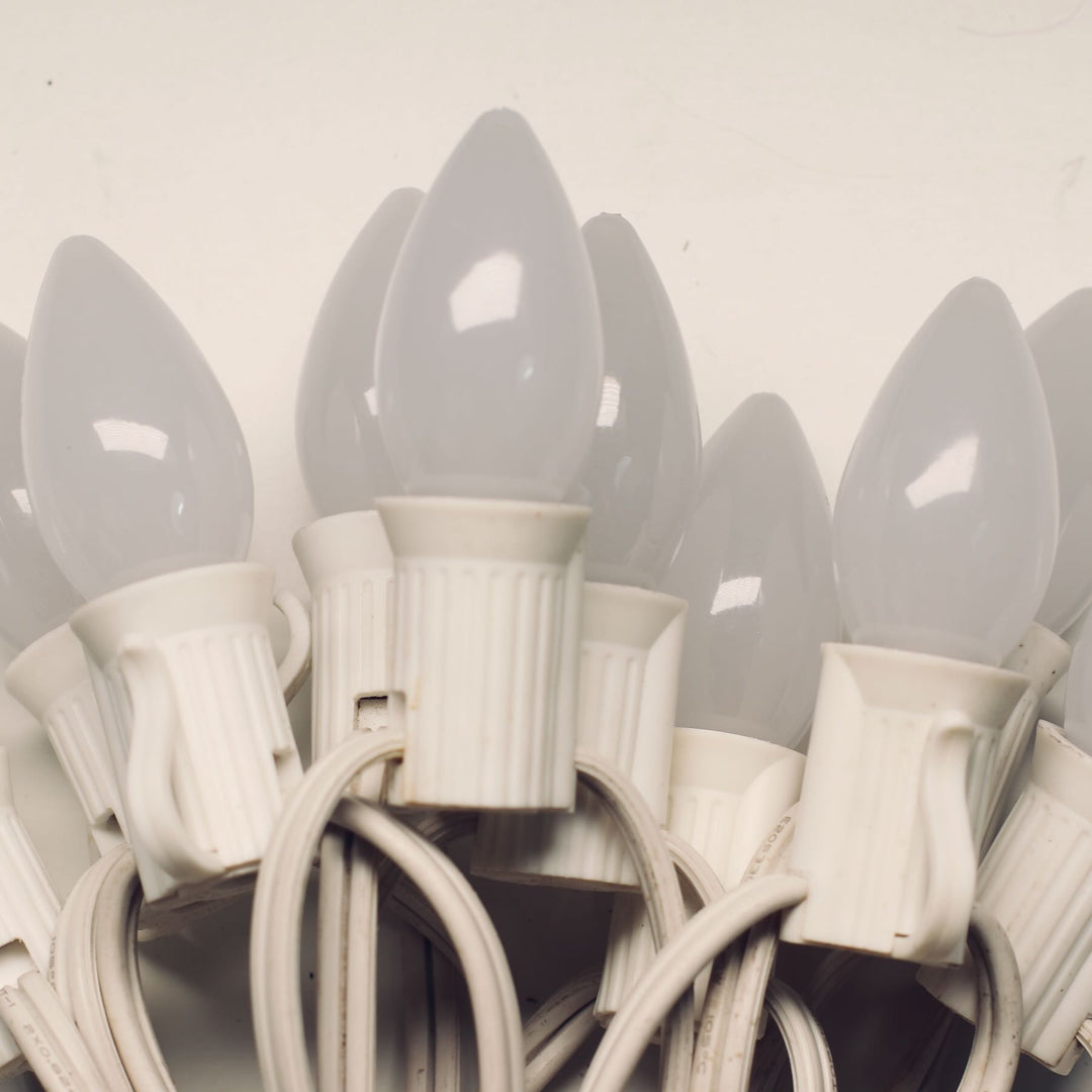 Close-up of multiple white light bulbs on a white background