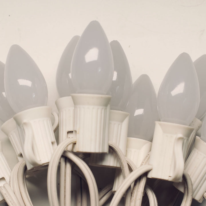 Close-up of multiple white light bulbs on a white background