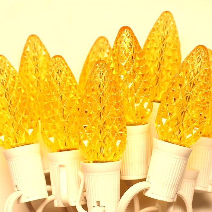 Yellow light bulbs with white bases on a beige background